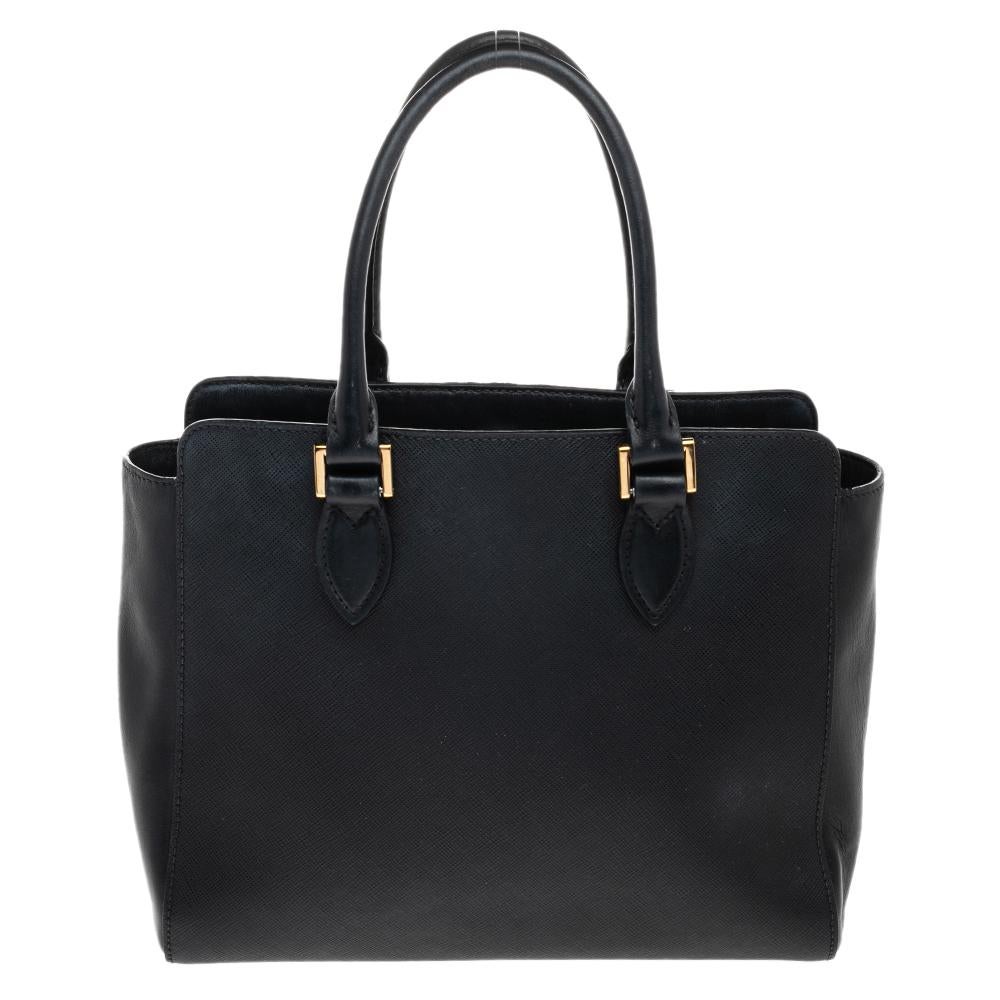 Masterfully stitched in Saffiano lux and soft calf leather, this bag can effortlessly hold more than just essentials. Carry all your belongings safely in the spacious interior lined with nylon. This Prada handbag, complete with two handles, will