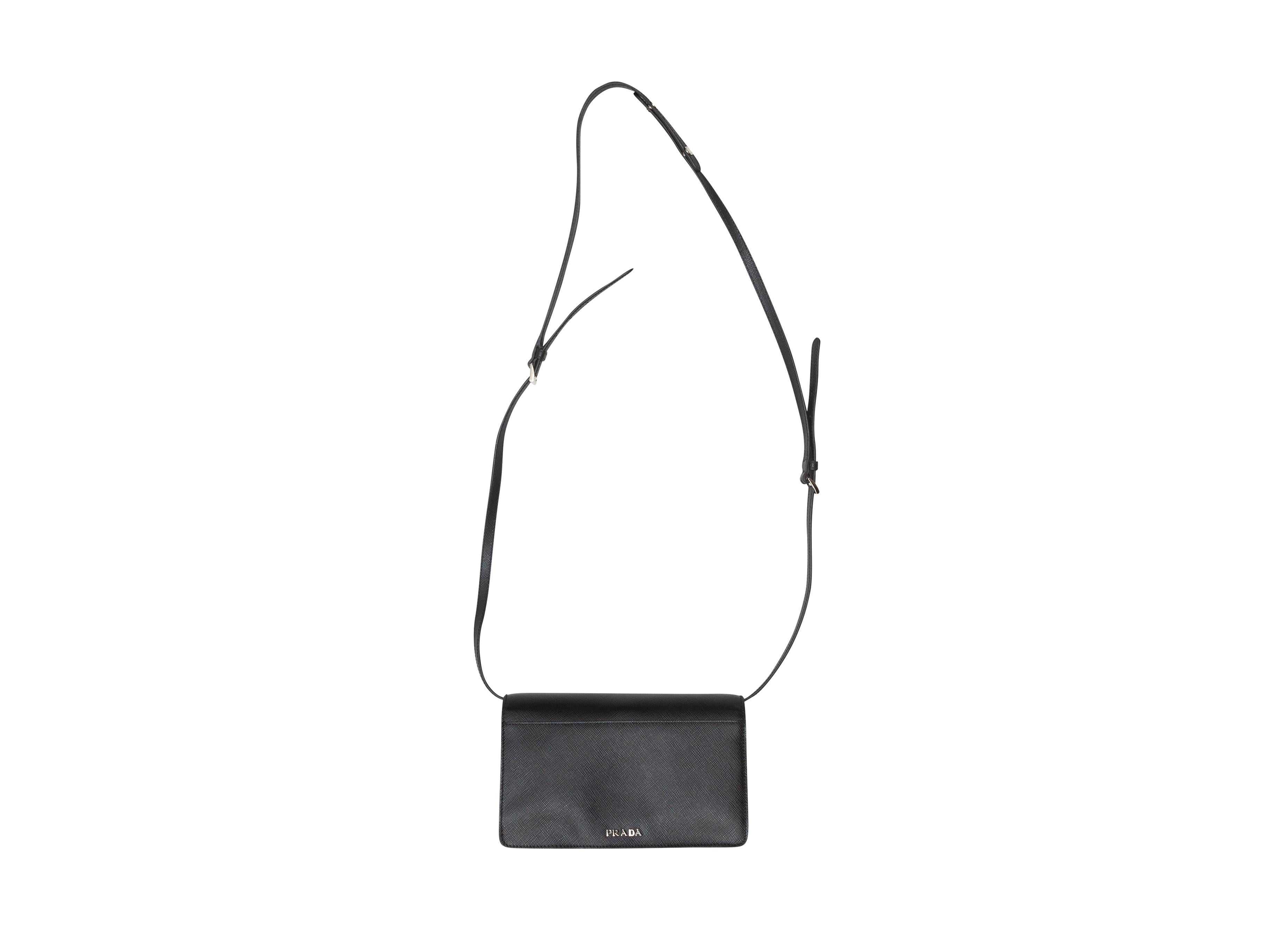 Product details: Black Saffiano Lux Flap Crossbody bag by Prada. Silver-tone hardware. Interior zip pocket. Adjustable shoulder strap. Turn-lock closure at front flap. 7.75