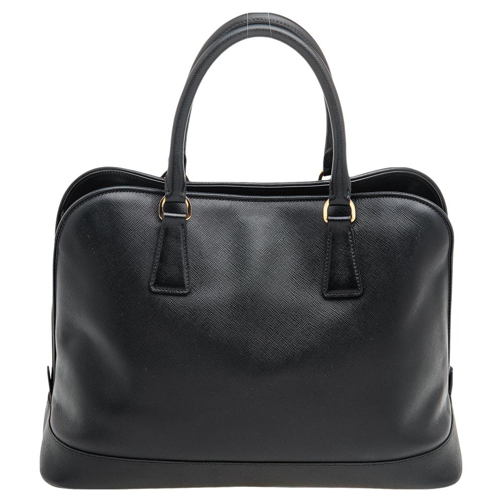 Add an element of charm to your everyday looks with this Prada satchel! It comes crafted from Saffiano Lux leather and is secured with a zipper. Fitted with two top handles, this bag is spacious enough to hold all your essentials and more. It opens