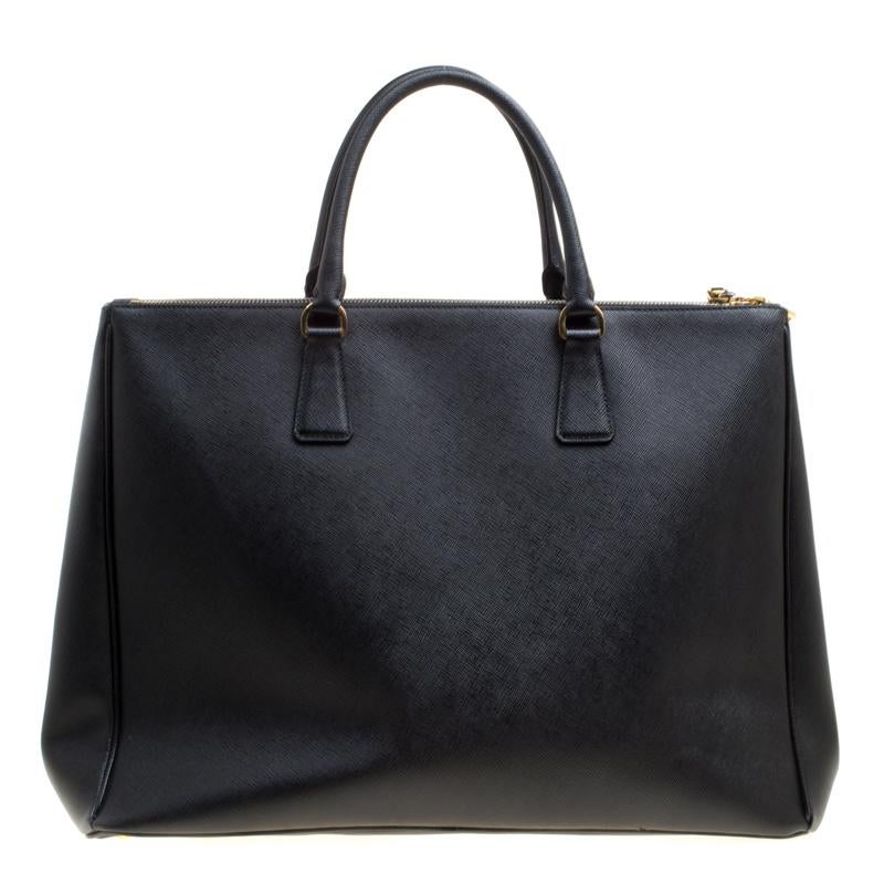 For women with an on-the-go lifestyle, this Executive Double Zip tote from the house of Prada is an elegant option. Masterfully designed, it is rendered in black Saffiano Lux leather and adorned with gold-tone hardware. The bag opens to an interior