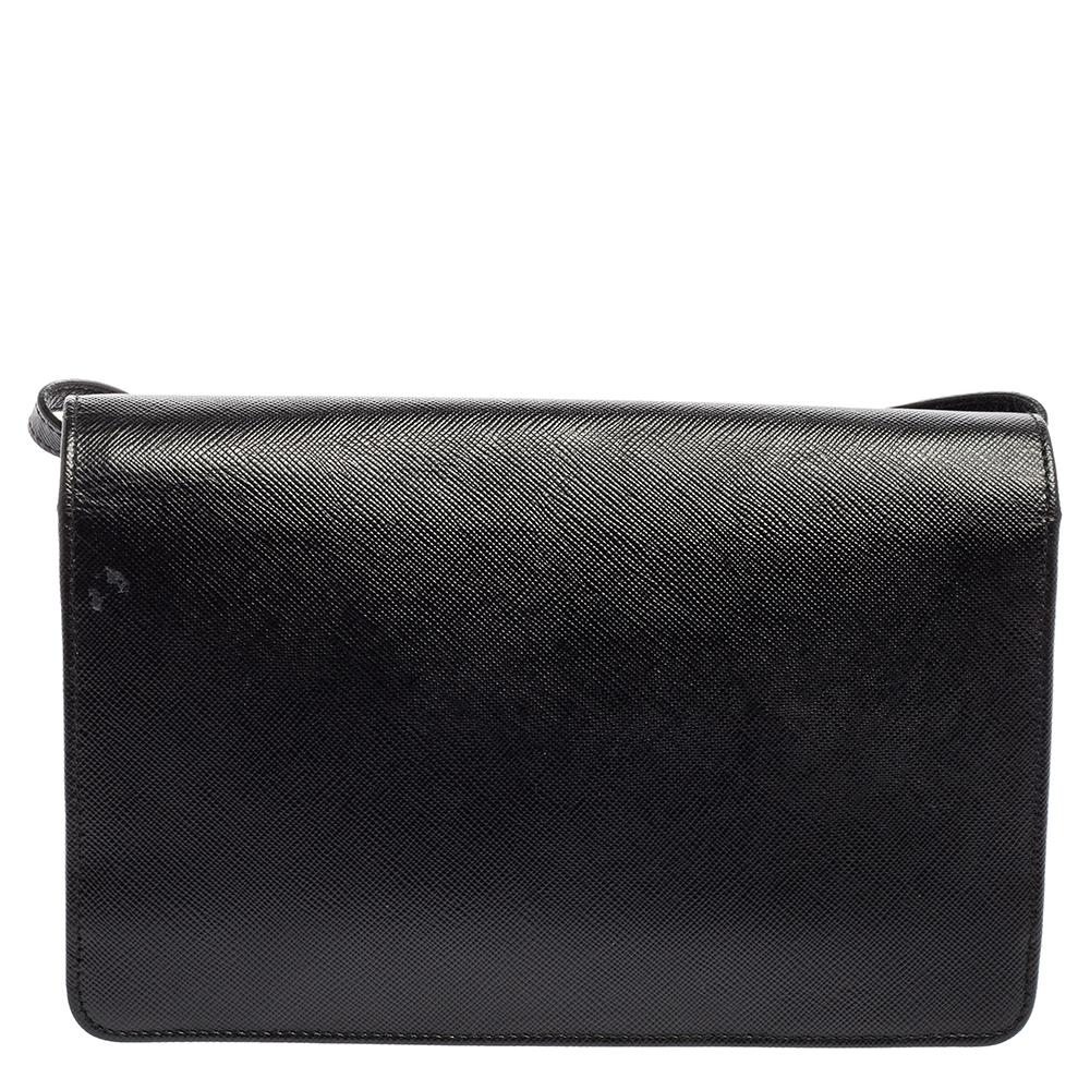 The Prada clutch bag is both practical and glamorous. Crafted from black-hued Saffiano Lux leather, this minimal creation, made in Italy, is presented in a streamlined silhouette with a front flap. The clutch opens to a nylon-leather interior
