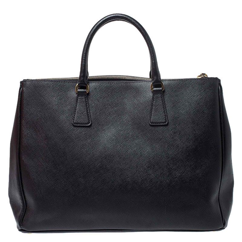 Feminine in shape and grand on design, this Double Zip tote by Prada will be a loved addition to your closet. It has been crafted from leather and styled minimally with gold-tone hardware. It comes with two top handles, two zip compartments and a