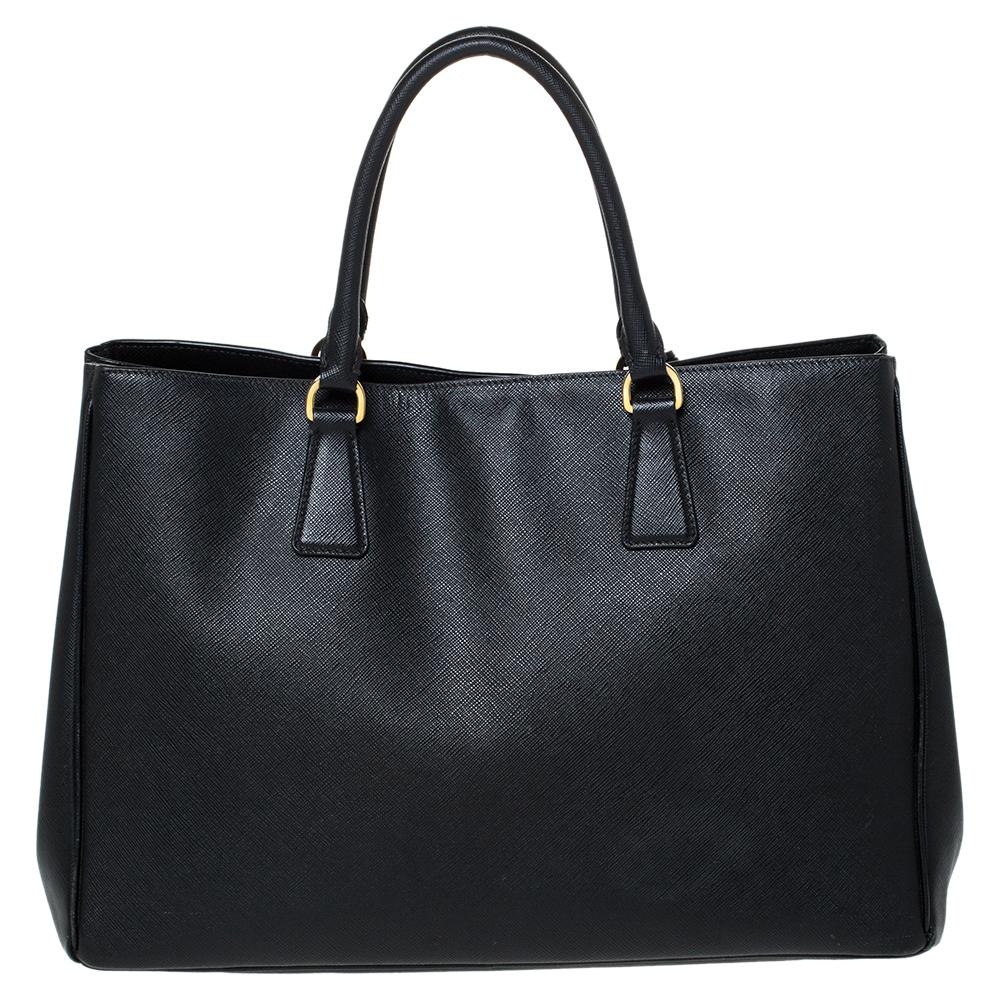 High in appeal and style, this tote is a Prada creation. It has been crafted from Saffiano Lux leather and shaped to exude class and luxury. The black bag comes with two handles and a spacious nylon interior for your ease. Protective metal feet and