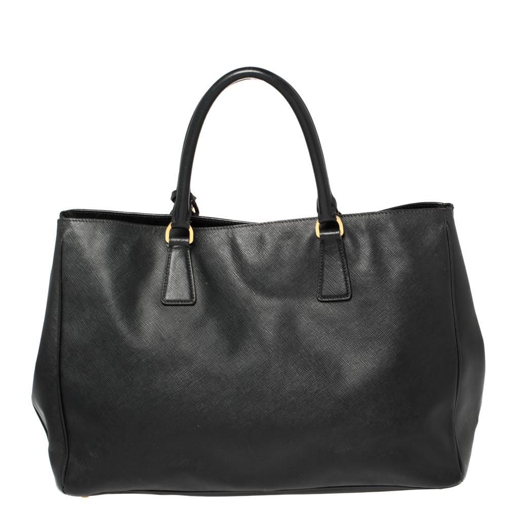 High in appeal and style, this tote is a Prada creation. It has been crafted from Saffiano leather and shaped to exude class and luxury. The bag comes with two handles and a spacious nylon interior for your ease. Protective metal feet and the brand