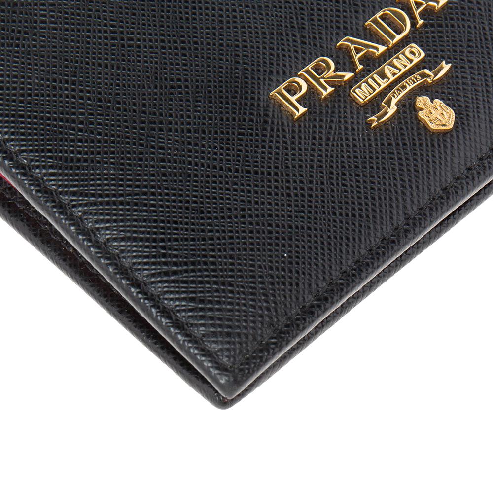 This compact wallet from the House of Prada is a great everyday accessory. It is made from black Saffiano Lux leather on the exterior, with a gold-toned logo perched on the flap. It features a leather-nylon interior. Add this Prada wallet to your
