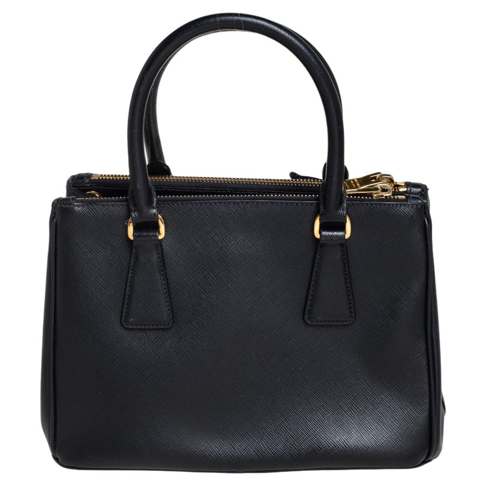 Loved for its classic appeal and functional design, Galleria is one of the most iconic and popular bags from the house of Prada. This beauty in black is crafted from Saffiano leather and is equipped with two top handles, the brand logo at the front