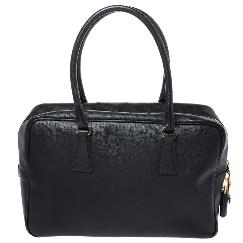 Masterfully created, this Prada satchel is a style icon. Designed in a Saffiano Lux leather body, it exudes style and class in equal measures. This delightful black piece is held by two top handles and equipped with a spacious nylon