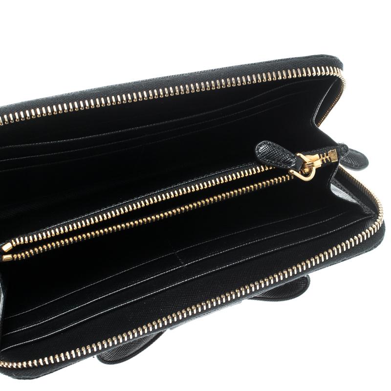 The durable leather construction of this wallet makes for the best accessory. Showcasing a pretty bow design on the front, this Prada wallet makes has a functional interior with multiple card slots. Be bold and stylish with this black