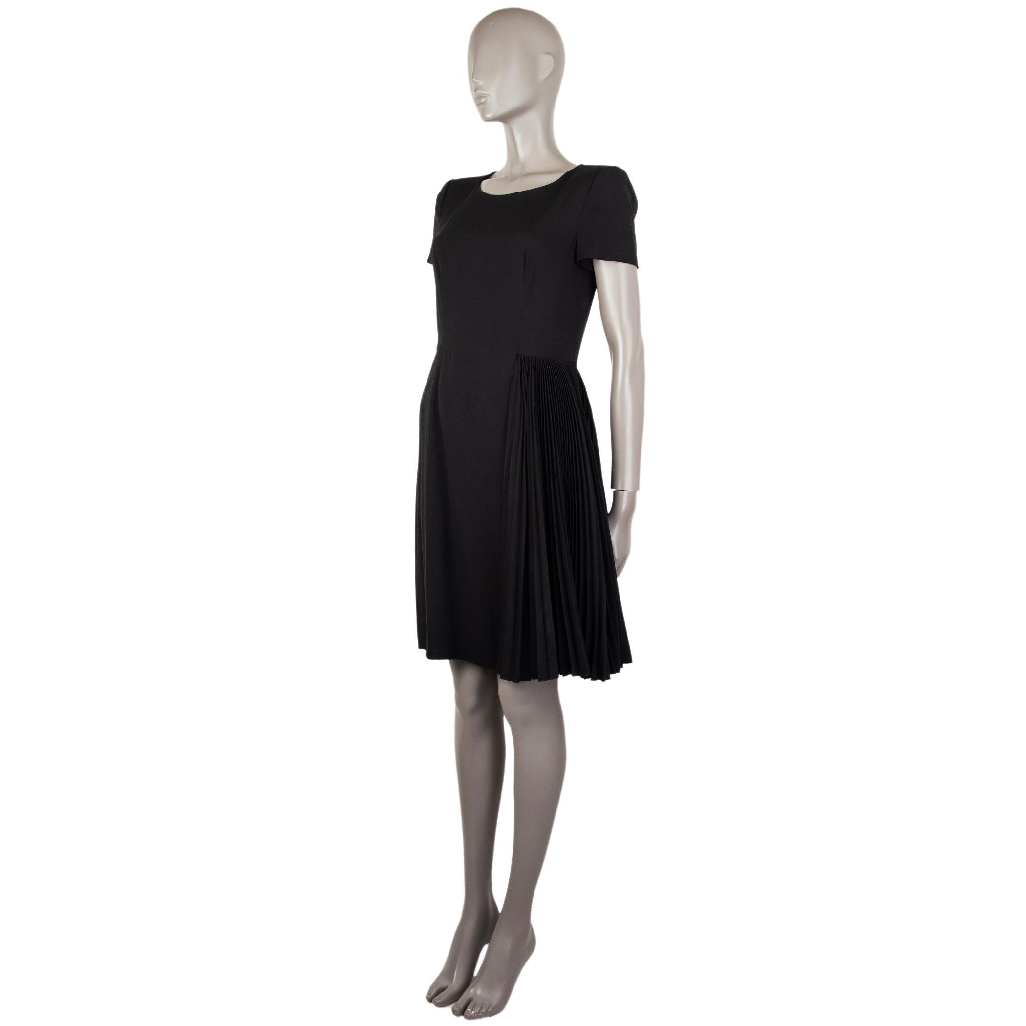 Prada short-sleeve dress in black polyester (57%) and viscose (43%). With padded shoulders and layered skirt with side plisse. Closes with hook and invisible zipper on the back. Lined in black cupro (60%) and silk (40%). Has been worn and is in