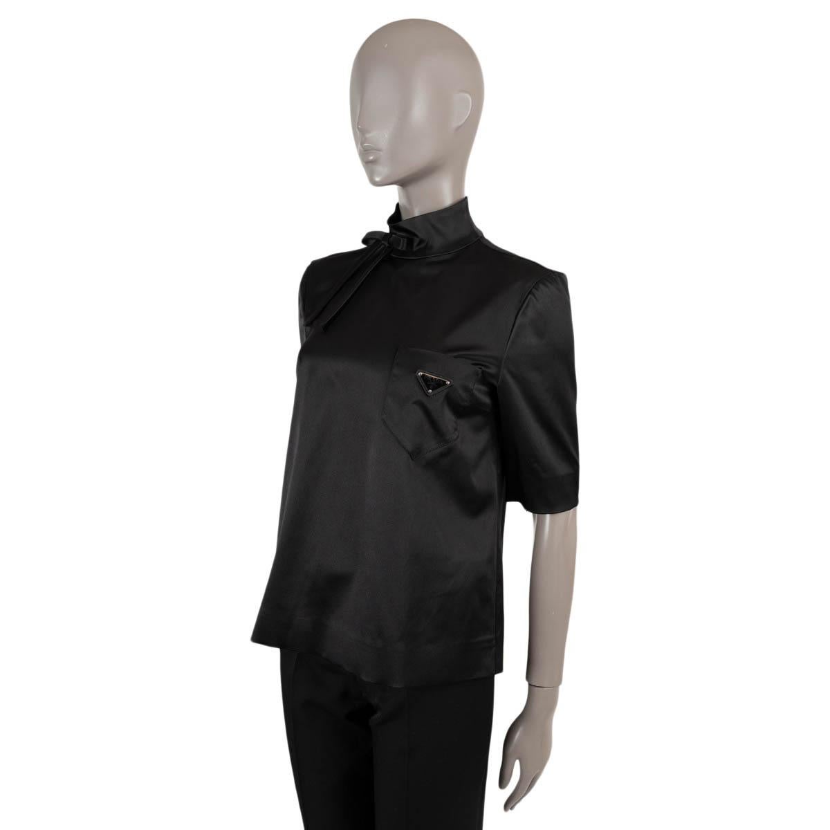 100% authentic Prada half sleeve blouse in black Duchesse silk (100%). Features a high-neck with bow and chest pocket with triangle logo. Opens with fabric covered buttons in the back. Has been worn and is in excellent condition.

2019