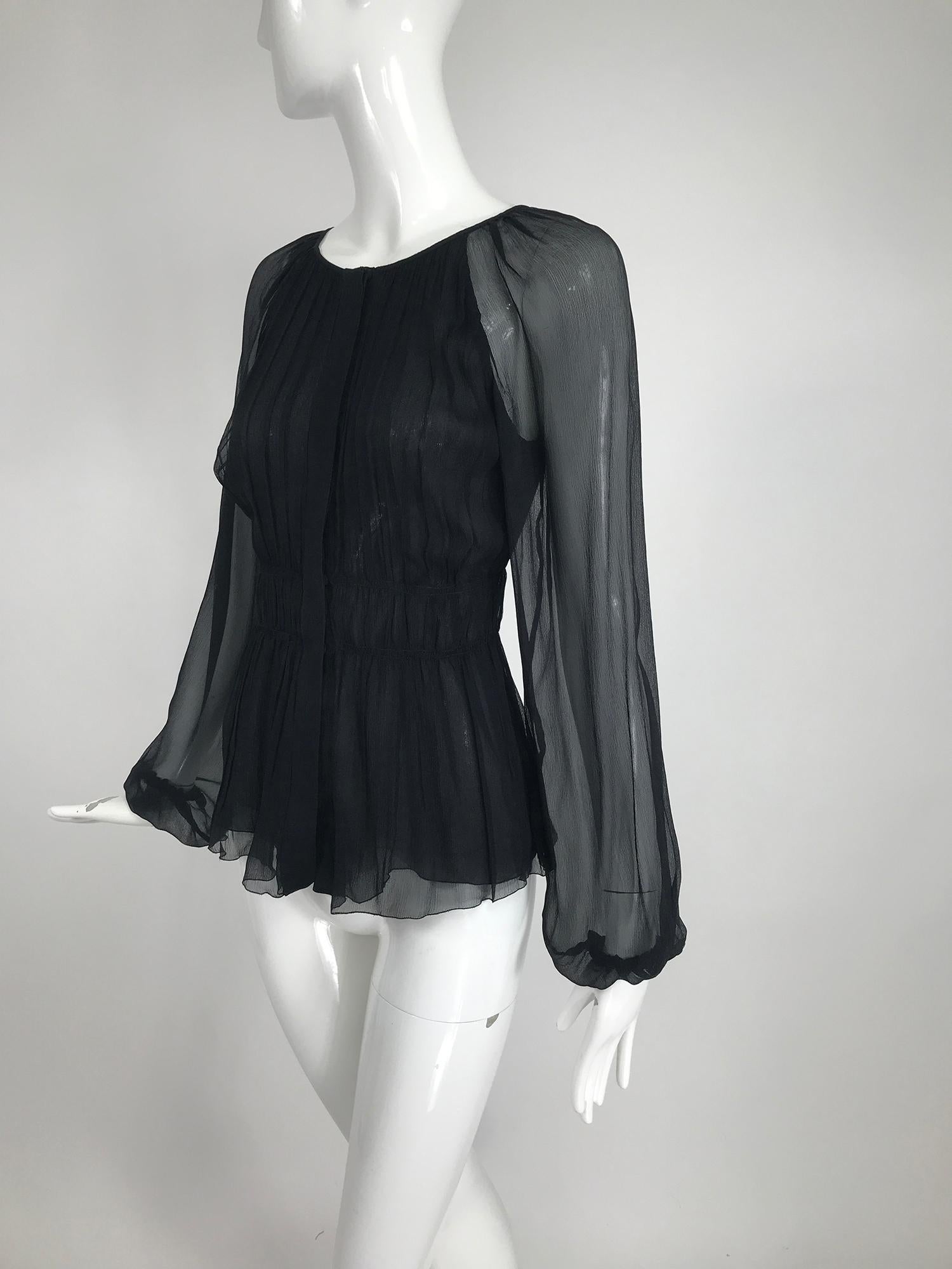 Prada sheer black silk chiffon jewel neck, blouse with a pleated gathered fitted torso and double narrow band waist. Long raglan sleeves are full and have cased elastic cuffs. The blouse closes at the front with buttons and hidden snaps. Blouse is