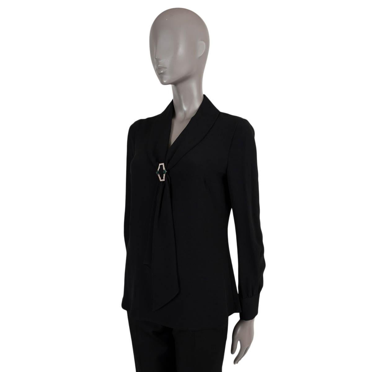 100% authentic Prada lavalier blouse in black silk (100%). Features a shawl collar with rhinestone encrusted gold-tone scarf ring in clear and green. Opens with a concealed zipper in the back. Has been worn and is in excellent