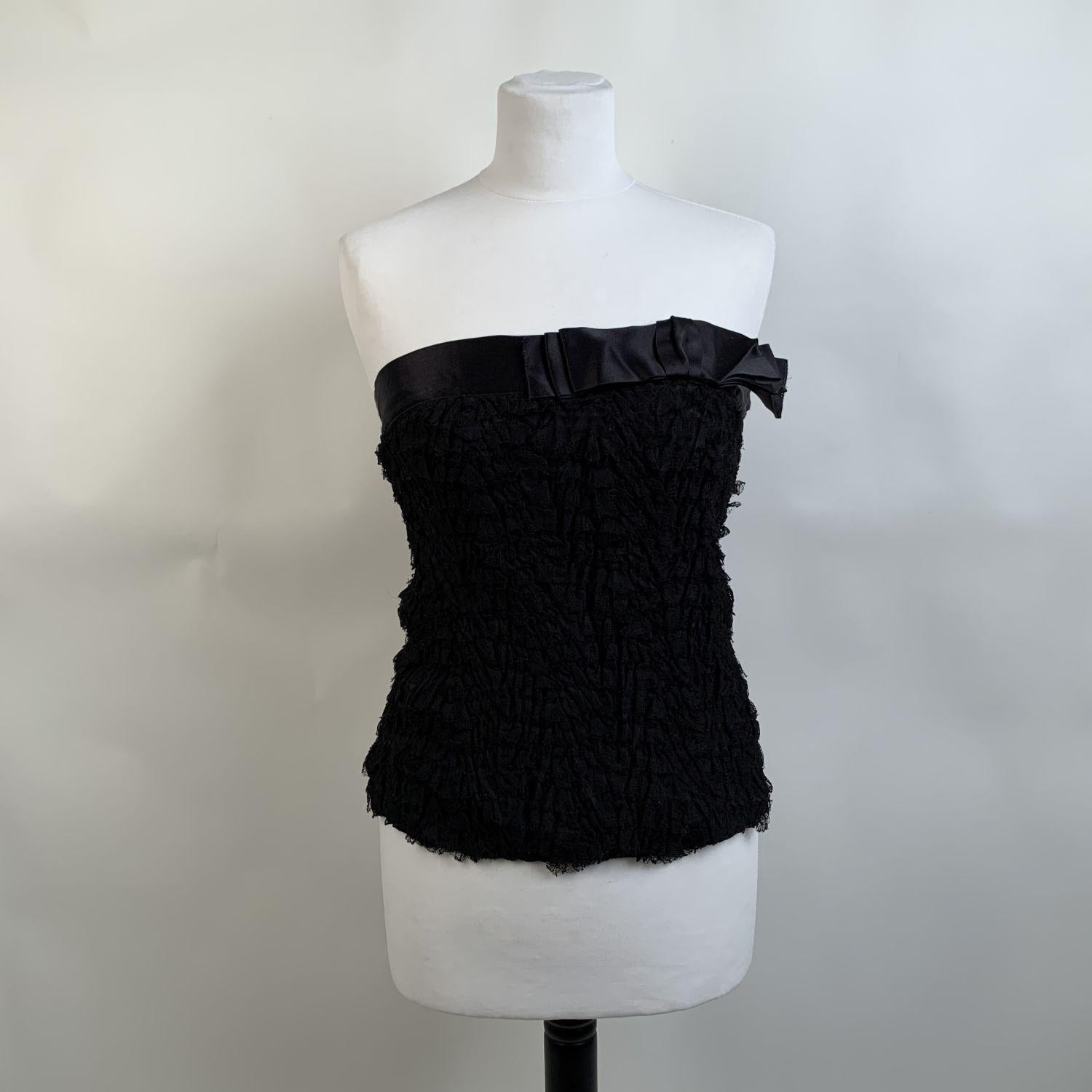 Prada bustier top in black color, with allover lace applications. Bow detailing on the neckline. Side button and hook and eye closures. Composition: 100% Silk. Application: 47% Nylon, 53% Viscose. Trimmings: 100% Silk. Size 40 IT (it should