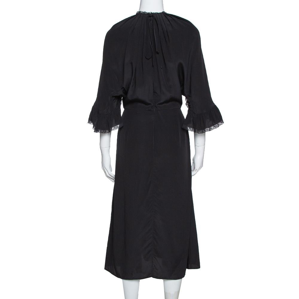 This dress from the house of Prada stands out beautifully. Style this elegant piece with dainty accessories for a unique and attractive look. Designed in a lovely black hue all over with ruffled trim on the front and a feminine midi silhouette, the