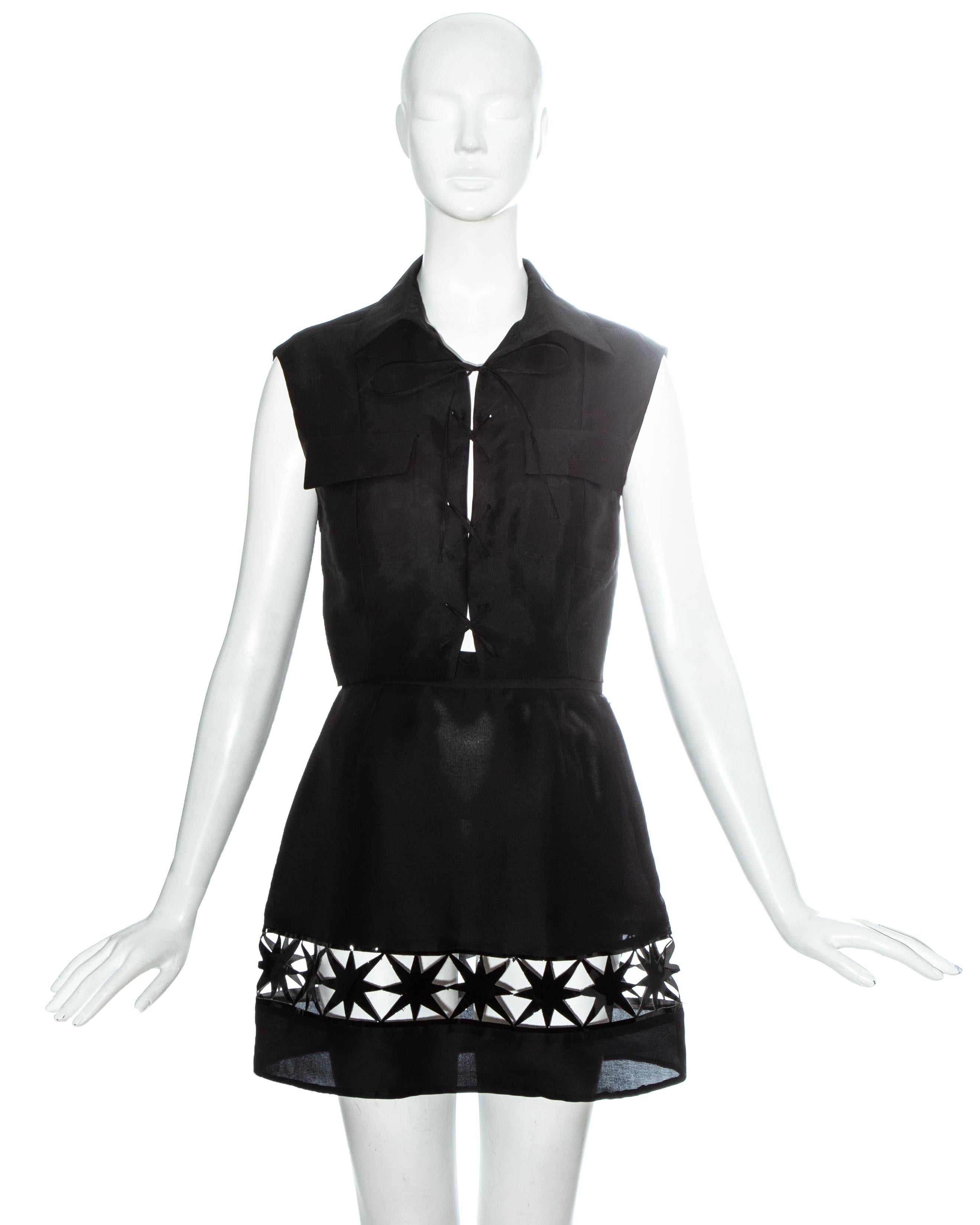 Prada black silk organza mini skirt and vest set. Safari style vest with two front flap pockets and lace up fastening. High waisted mini skirt with leather stars and cut out panel

Spring-Summer 1993