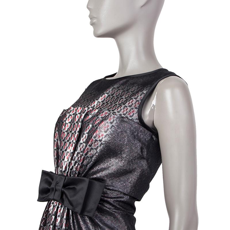 Prada sheath dress in black, silver, and red silk (73%) and polyester(27%). With round neck, pleated front held by a black satin bow on the waist, black satin trims, and horizontal pleats on the back. Closes with concealed metal zipper on the back.