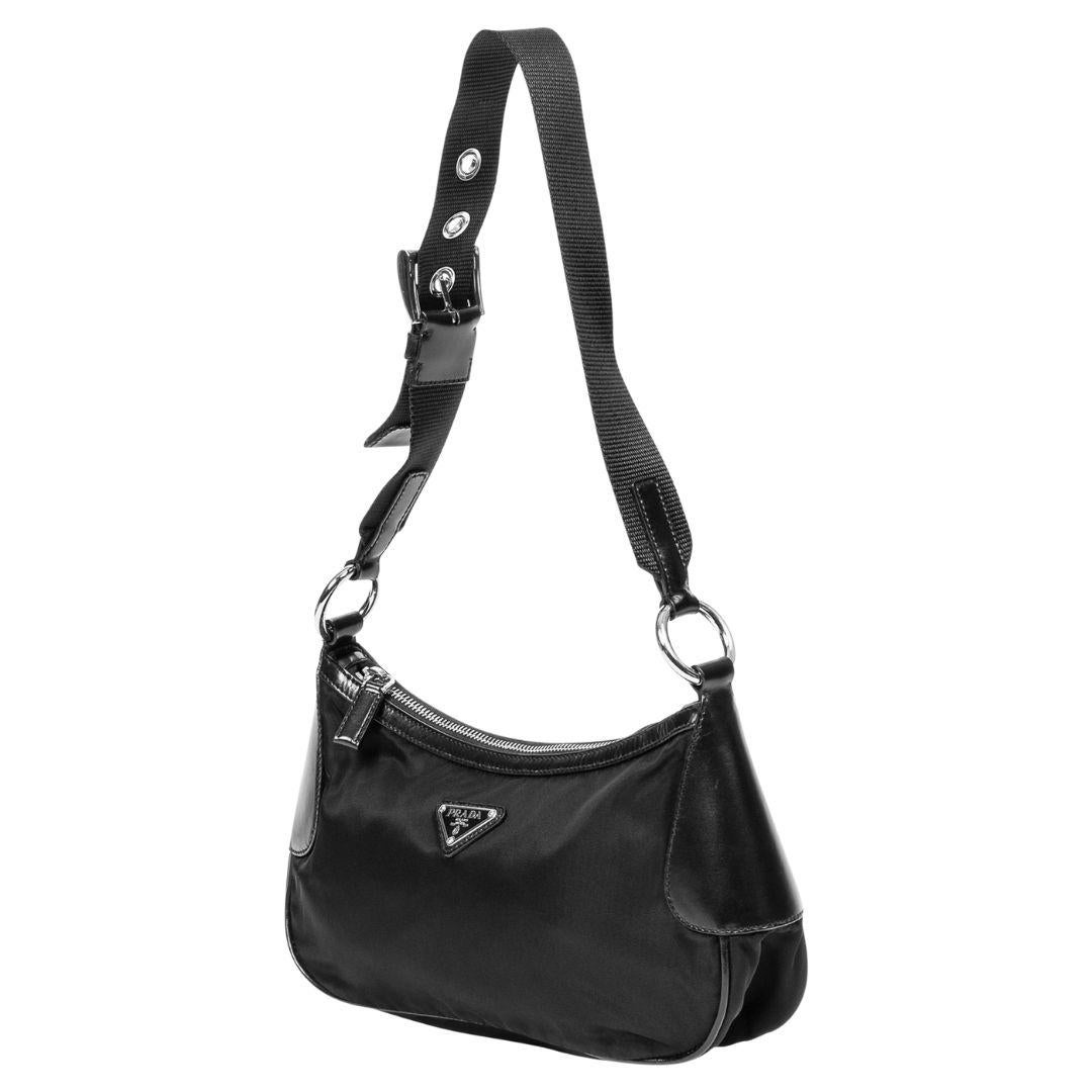 A versatile black nylon canvas hobo bag with a silver zipper closure. The interior features a logo jacquard lining and one zippered pocket for secure storage.

SPECIFICS
Length: 10.6
Width: 3
Height: 5.1
Strap drop: 12 (adjustable)
Authenticity
