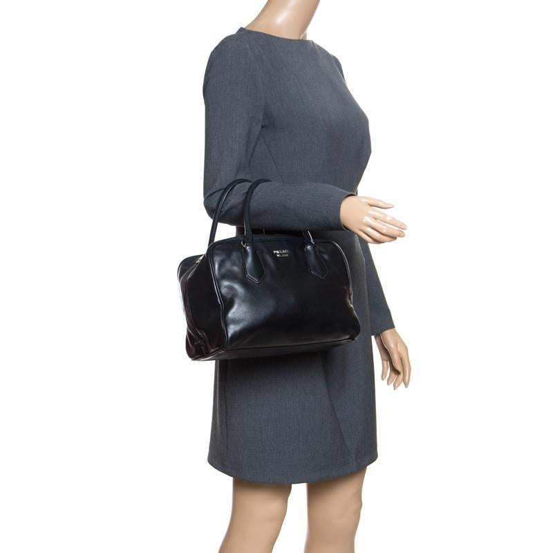 When you carry this Prada creation, be ready to catch admiring glances as this bag is stylish and handy. The bag has been crafted from soft leather in a black shade and equipped with two top handles and a very spacious leather interior.

Includes: