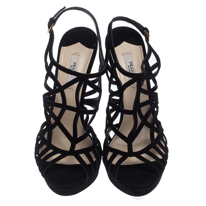 Look stunning in these luxurious sandals from Prada. The sandals are crafted from suede and feature open toes and a caged design, buckled ankle straps, and 13.5 cm stiletto heels. These black sandals are versatile and can be worn on any