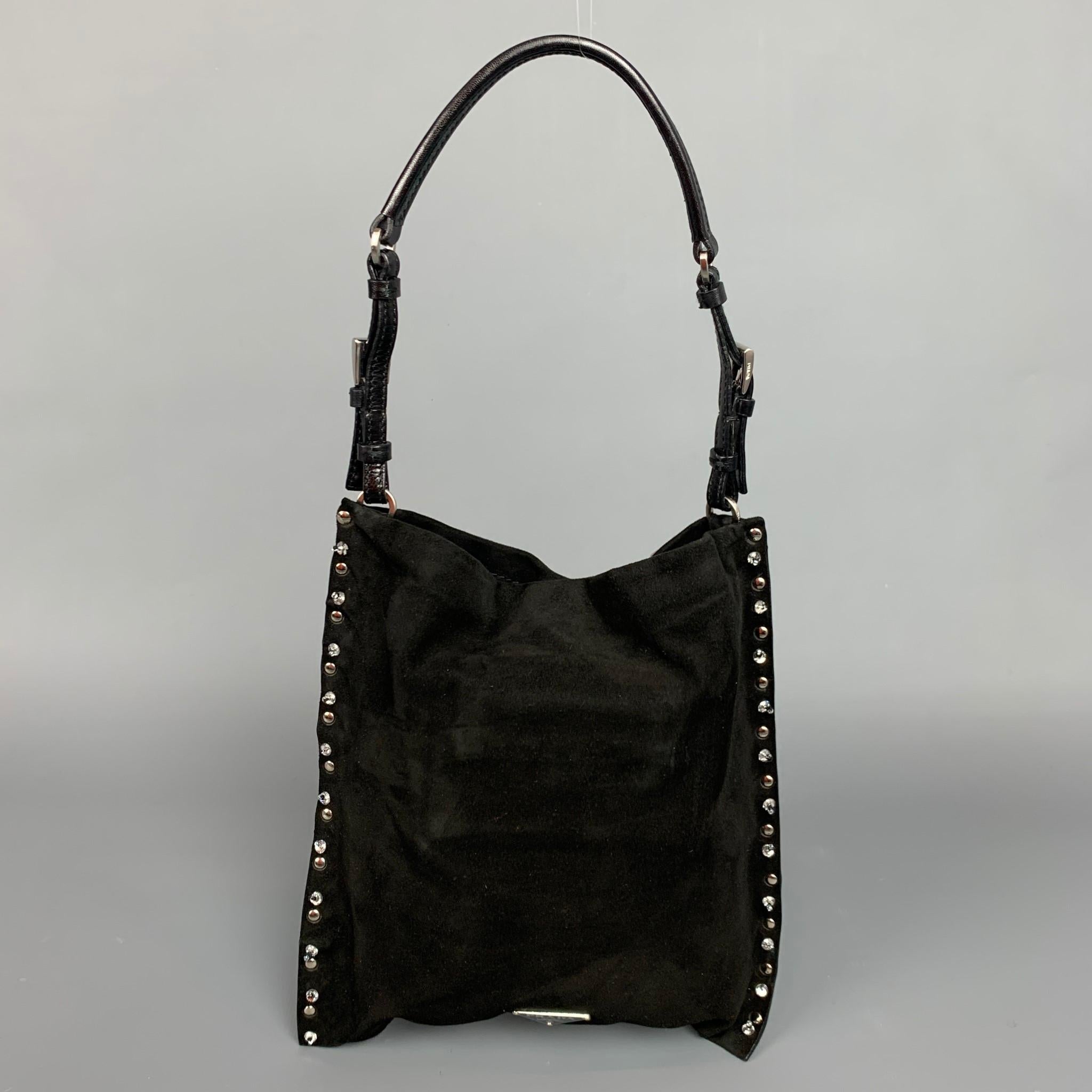PRADA handbag comes in a black suede with a nude satin liner featuring embellished rhinestones, adjustable top handle, inner pocket, and a snap button closure. Comes with dust bag and identification cards. Made in Italy.

Very Good Pre-Owned