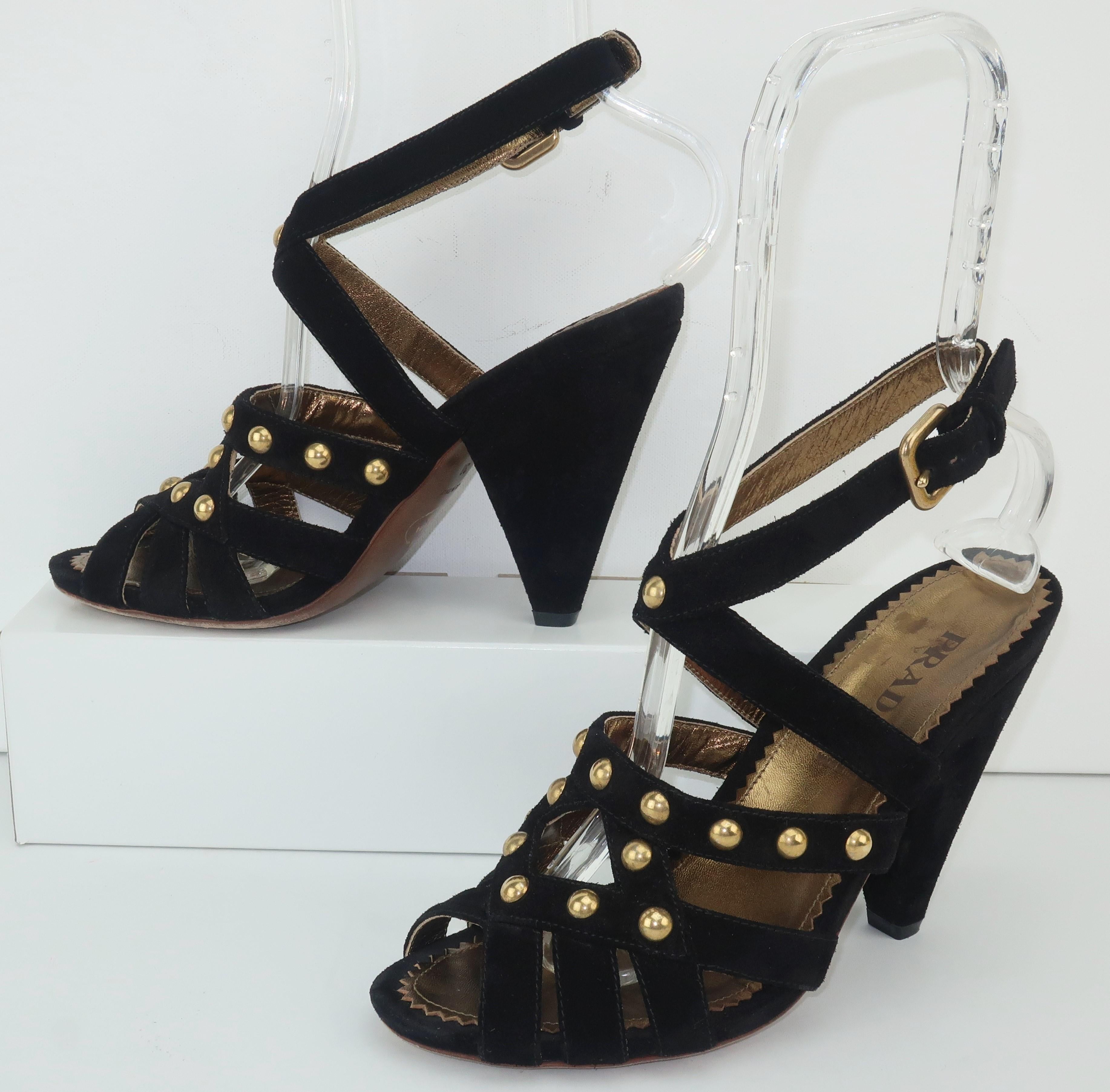 These contemporary Prada shoes have a good dose of inspiration from the avant-garde fashions of the 1930's.  The black suede strappy upper sports an adjustable buckle at the ankle and is decorated with gold studs.  The cone shaped 4.5