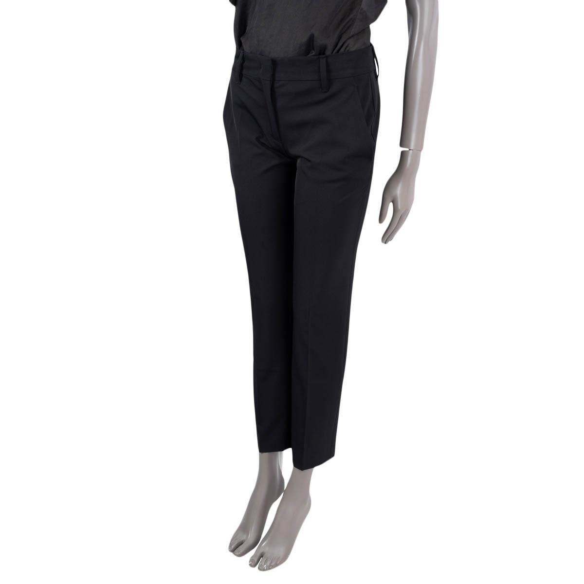 Ce pantalon technique extensible 100% authentique de Prada est confectionné en polyester recyclé noir (89%) et en élasthanne (11%), offrant une coupe élégante et souple. Ils sont dotés de passants de ceinture, de deux poches latérales et de deux