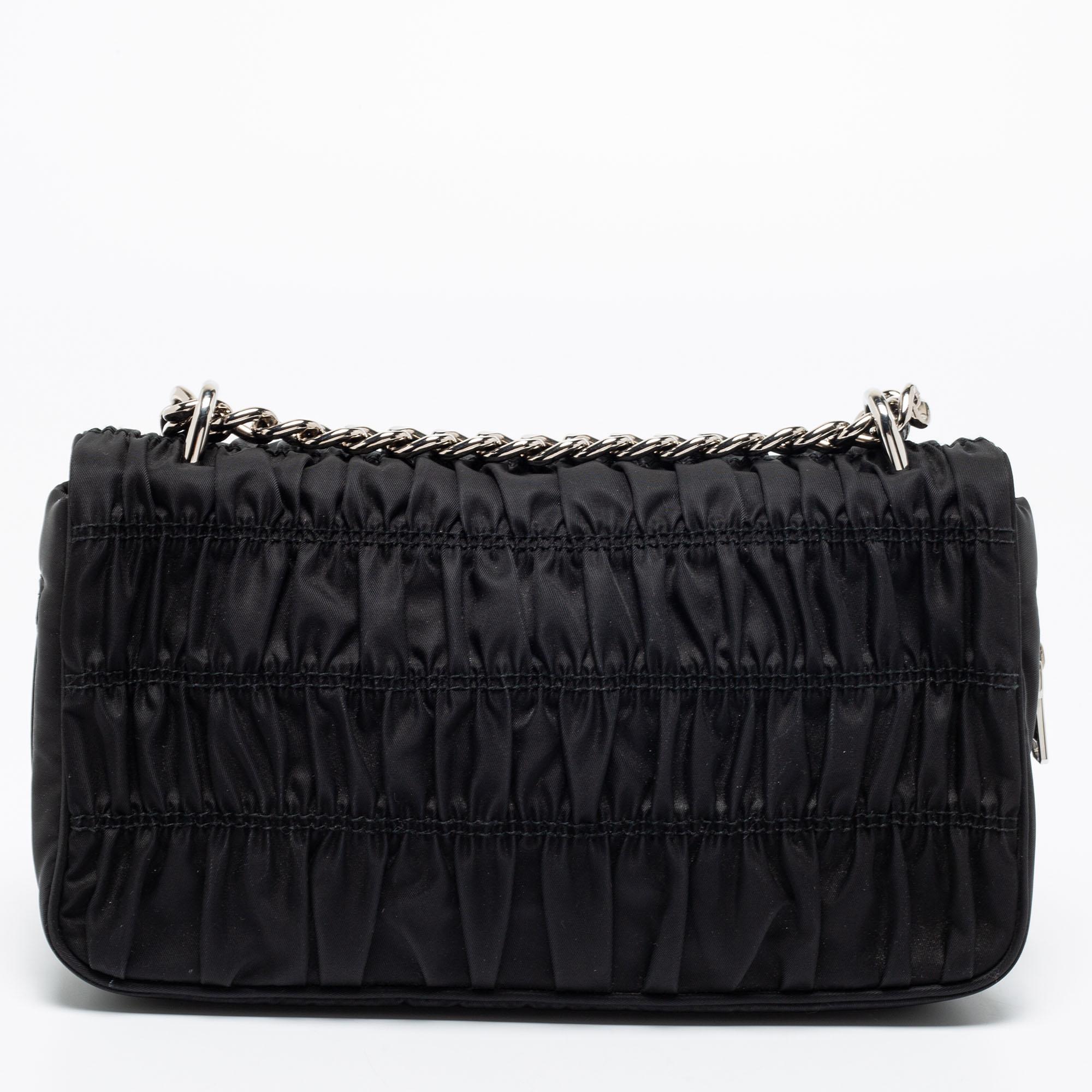 Masterfully created, this Prada shoulder bag is a style icon you cannot do without. Carry this chic black bag to complete your casual everyday look. It has a long chain strap, silver-tone detailing, and a flap closure that reveals a capacious