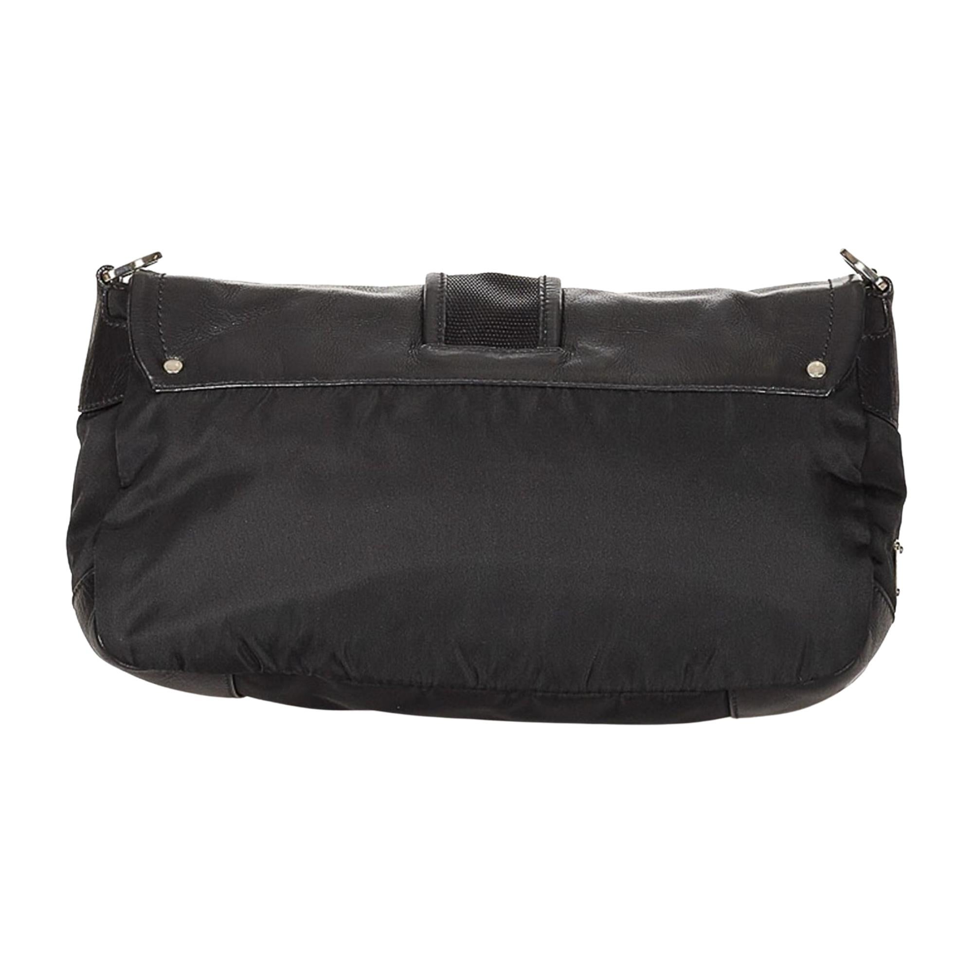 This bag features a black nylon body with leather trim and details with a front buckle to secure the top flap with magnetic snap closure. The bag is finished with top zip closure, 2 zip compartments at the from and logo jacquard black woven fabric