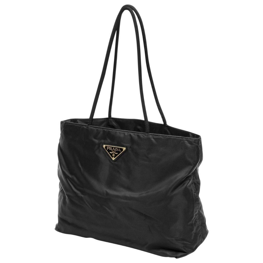Timeless 90s treasure! This is suitable for every wardrobe collection. Crafted in black tessuto nylon with the signature Prada logo plate, dual rolled shoulder straps, silver-tone hardware. The top zipper opens up to a logo Jacquard interior with