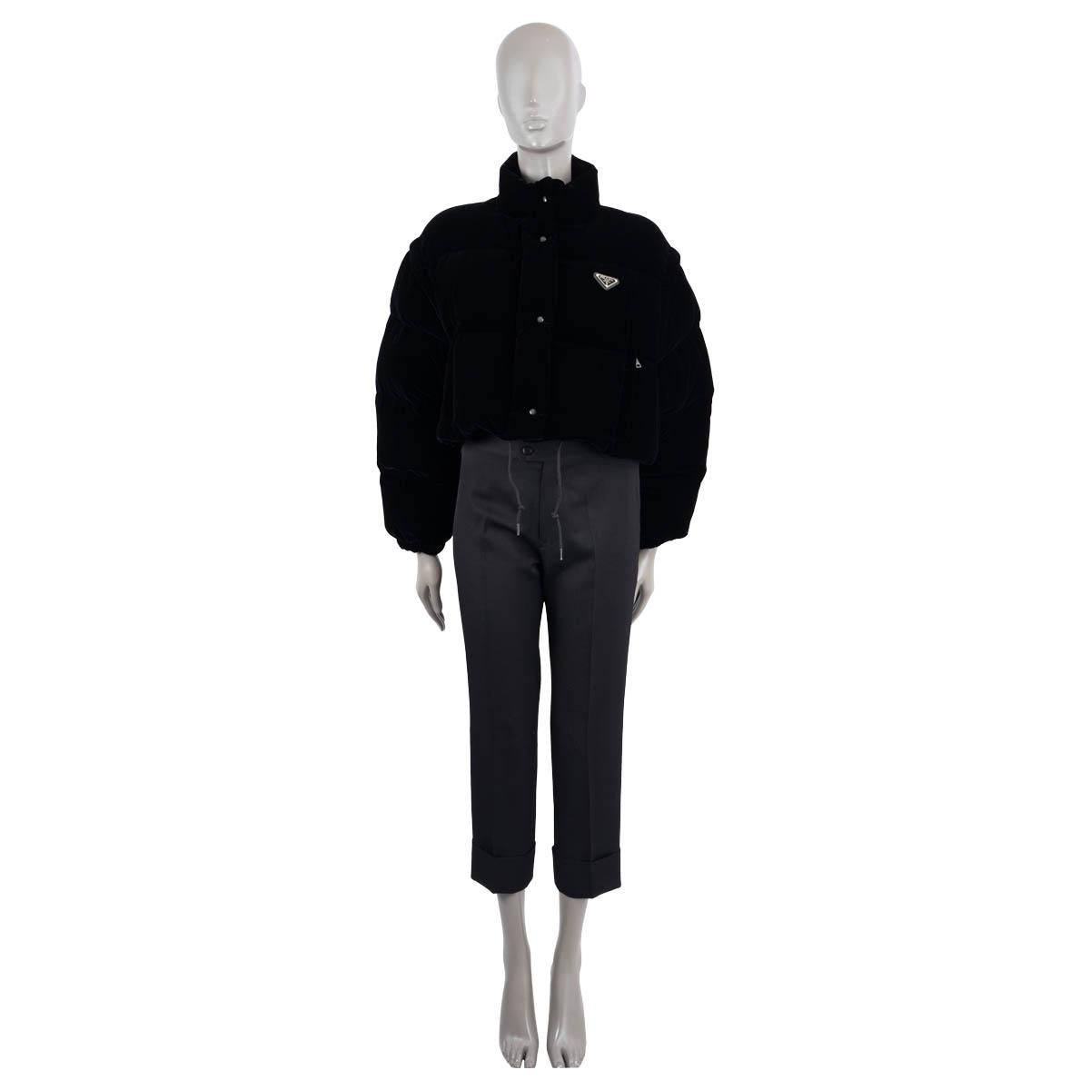 100% authentic Prada 2022 convertible cropped black velvet down jacket made of viscose (70%) and cupro (30%). The design can transform into a vest thanks to the removable sleeves. The goose-down padded jacket is embellished with the brand's