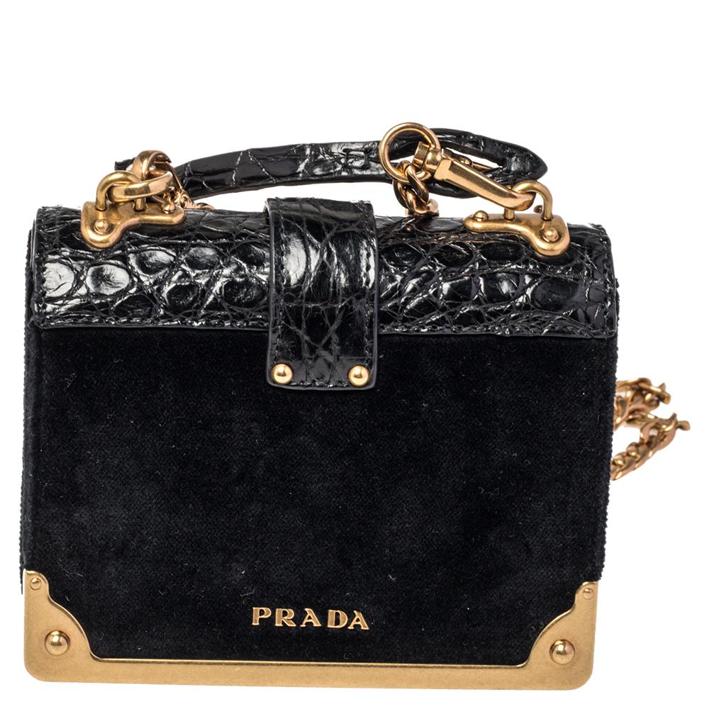 Impeccably designed in croc-embossed leather & velvet, this Cahier crossbody bag by Prada is the perfect one for the modern fashionista. Lined with fine leather, this black-hued bag delivers trendy looks as well as functionality. It has a front