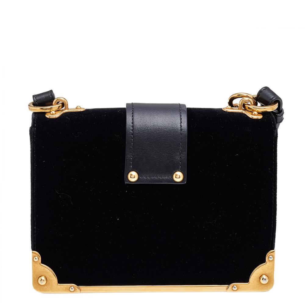 Inspired by valuable books from ancient times, the Cahier by Prada is a best-seller. This bag is crafted using velvet, leather, and gold-tone hardware. The flap closure with the brand logo opens to a leather-lined interior with space for your