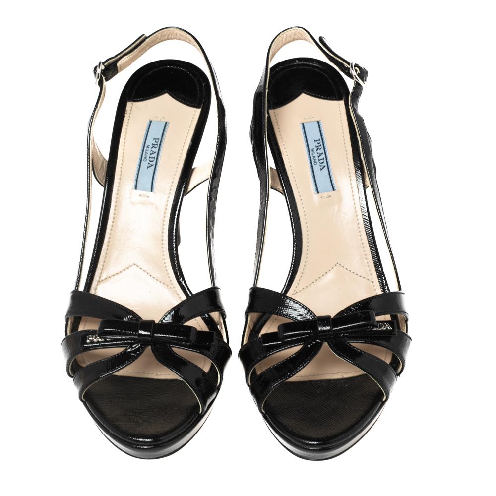 Prada presents to you this gorgeous pair of slingback sandals in black color. They have been meticulously crafted from Saffiano leather and feature open-toes along with pretty bow details on the front. Silver-tone hardware and high heels complete