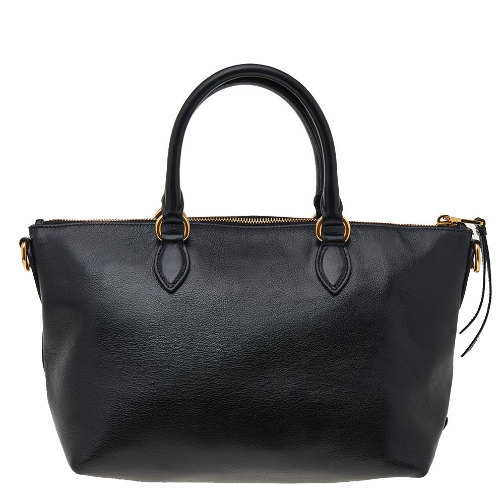 This lovely tote from Prada is crafted from Vitello Daino leather and features a black shade. It flaunts dual handles, the logo embossed on the front, and a spacious nylon-lined interior. Perfect to complement most of your outfits, this bag is