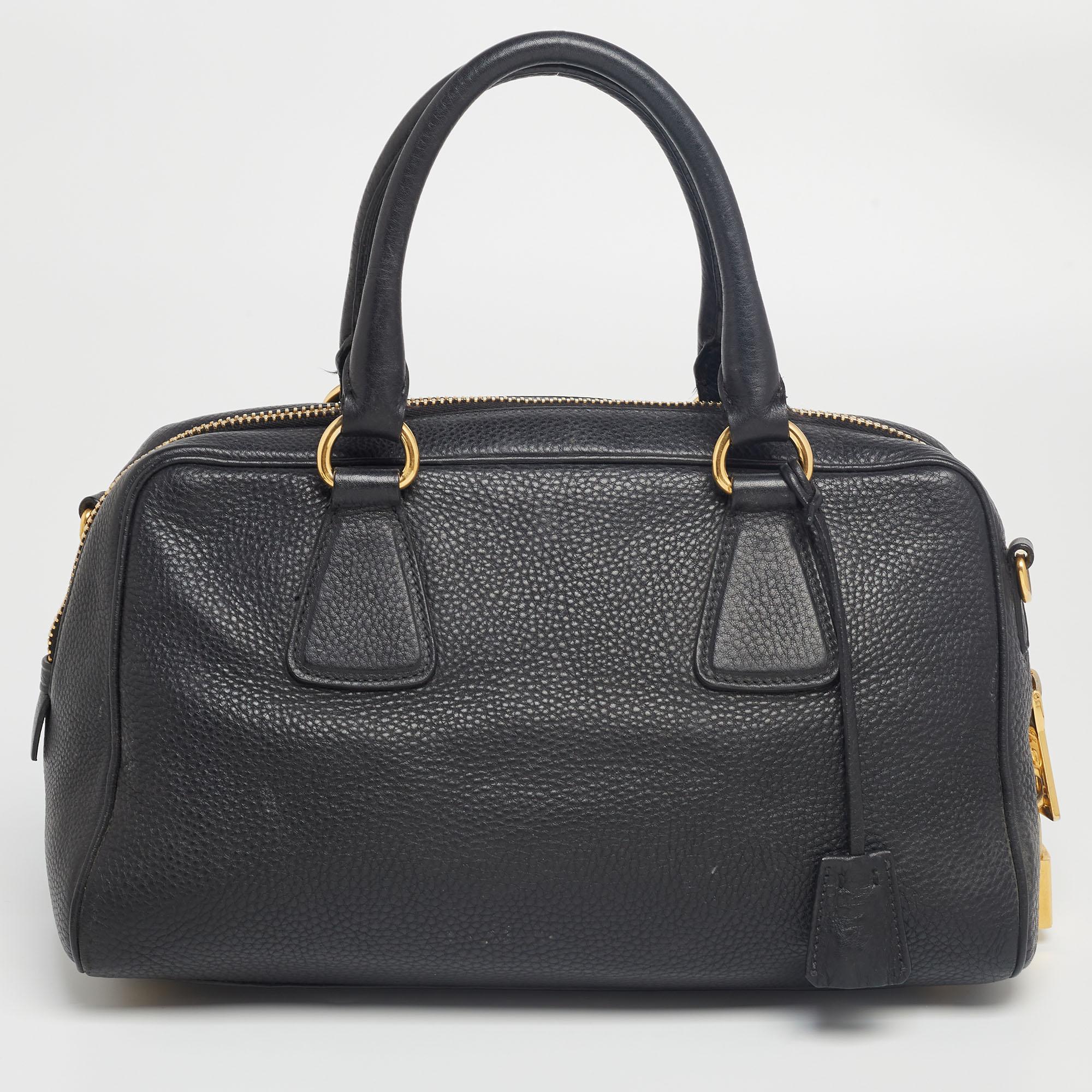 This satchel from the House of Prada is great for everyday use. It is made from black Vitello Daino leather, which is embellished with gold-tone hardware. It showcases dual handles and is provided with a nylon-lined interior. This Prada satchel will
