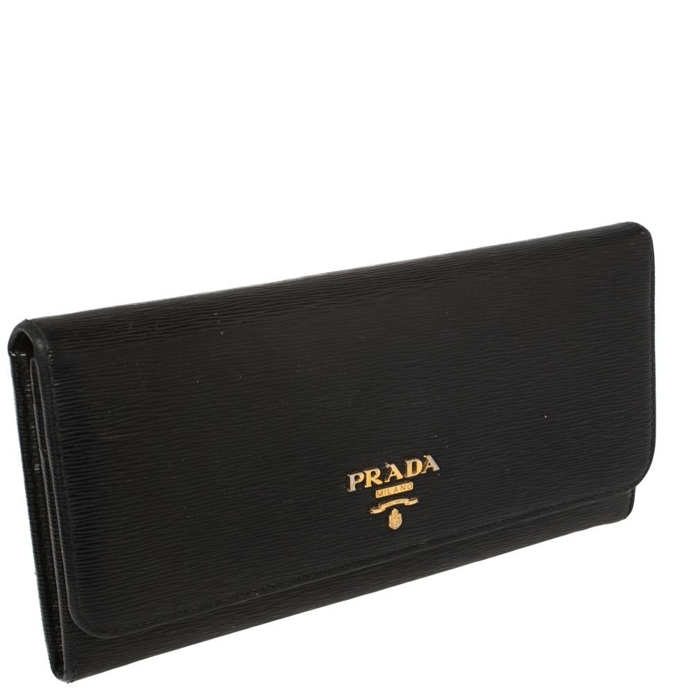 Ensure your essentials are in order with this Continental wallet from Prada. Crafted using leather, the black wallet for women has a back zip pocket and a front flap closure to secure the well-designed interior. The Prada logo on the front adds a
