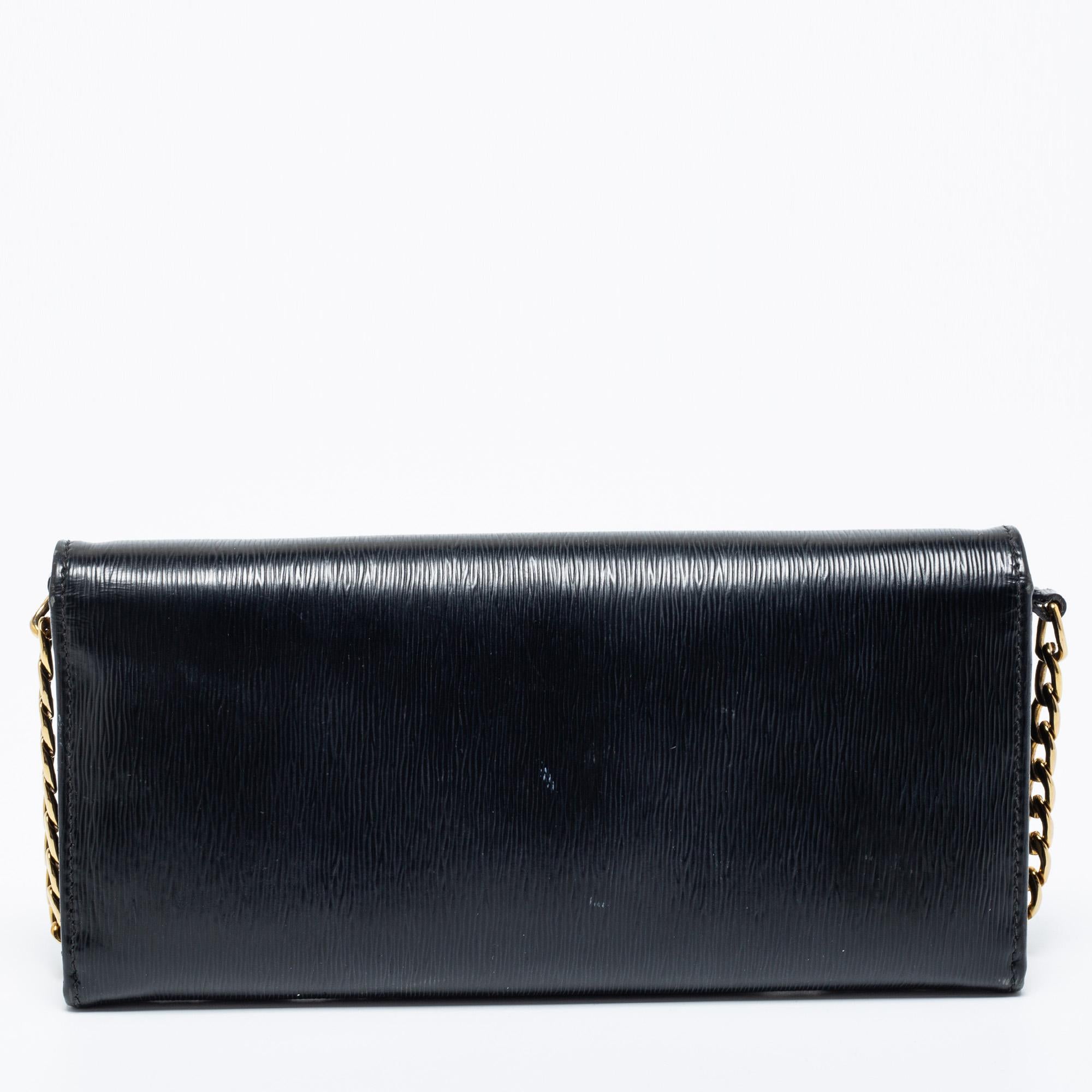 Now here's a creation that is both stylish and functional. Prada brings us this wallet on chain that will make you look glamorous as you carry it! It is made from black Vitello Move leather, with a gold-tone logo accent attached to the front. It is