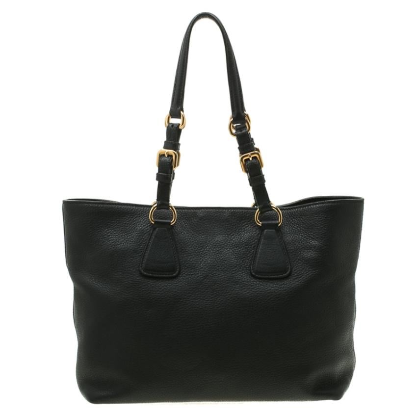 This Prada creation will fetch you admiring glances as this tote is stylish and handy. The bag has been crafted from black leather and is equipped with dual buckle handles and the logo on the front. The tote comes with a spacious nylon lined