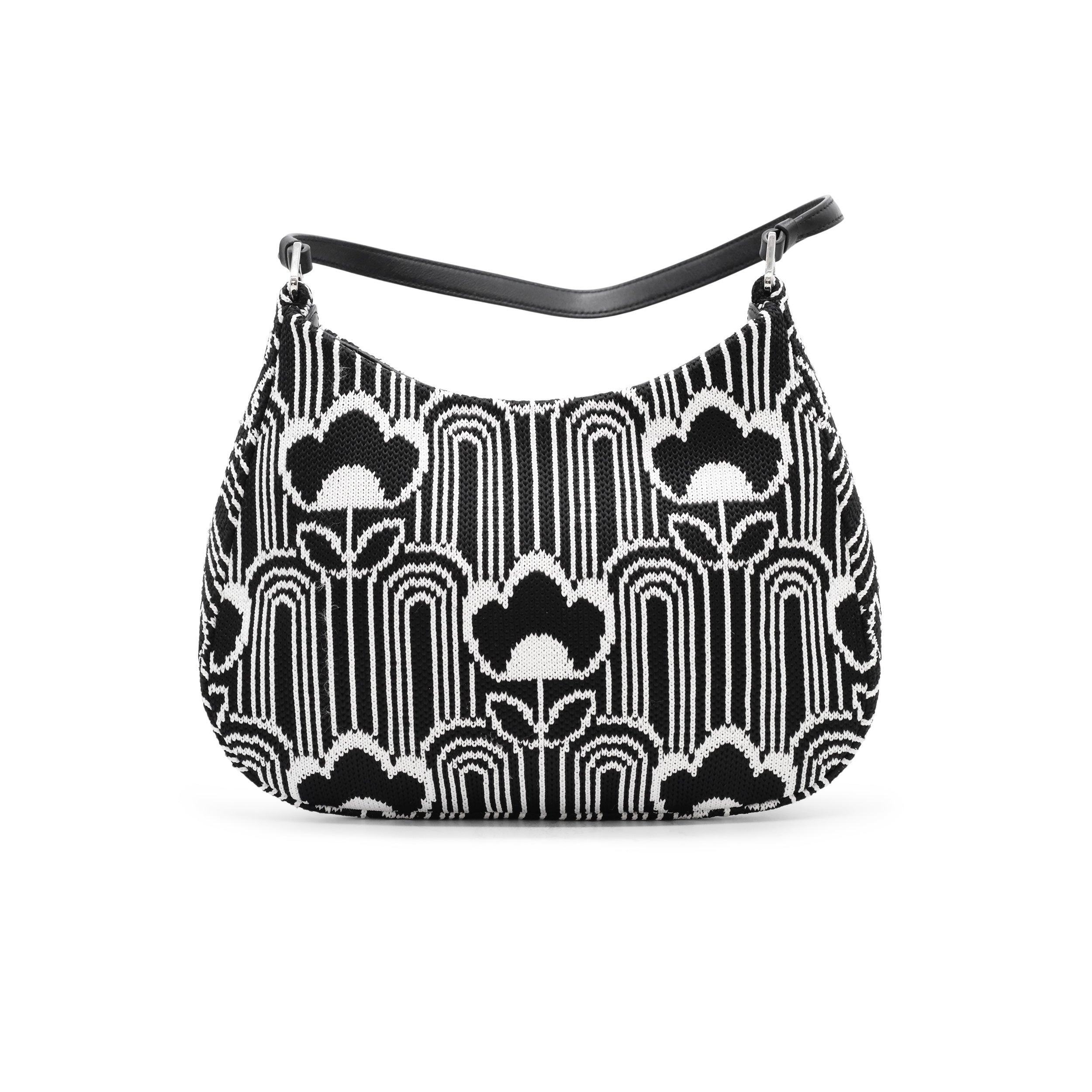 This stylish Prada Cleo Shoulder Bag features a jacquard knit exterior with calfskin leather trim and silver-tone hardware. The black and white wicker detailing adds a chic touch, while the flat shoulder strap ensures comfort. Inside, a black