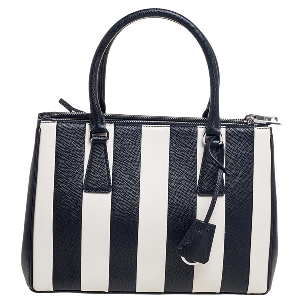 Loved for its classic appeal and functional design, Galleria is one of the most iconic bags from the house of Prada. This beauty in black and white stripes is crafted from leather and is equipped with two top handles, the brand logo at the front,