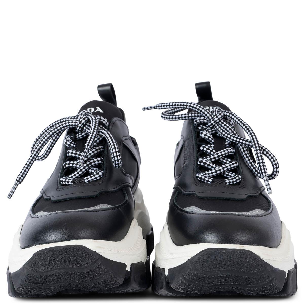 100% authentic Prada Pegasus platform sneakers in black and reflective silver-tone nylon and leather set on a chunky white rubber sole. Logo printed in white at padded tongue. Padded collar. Pull-loop at heel collar. Rubberized Velcro strap