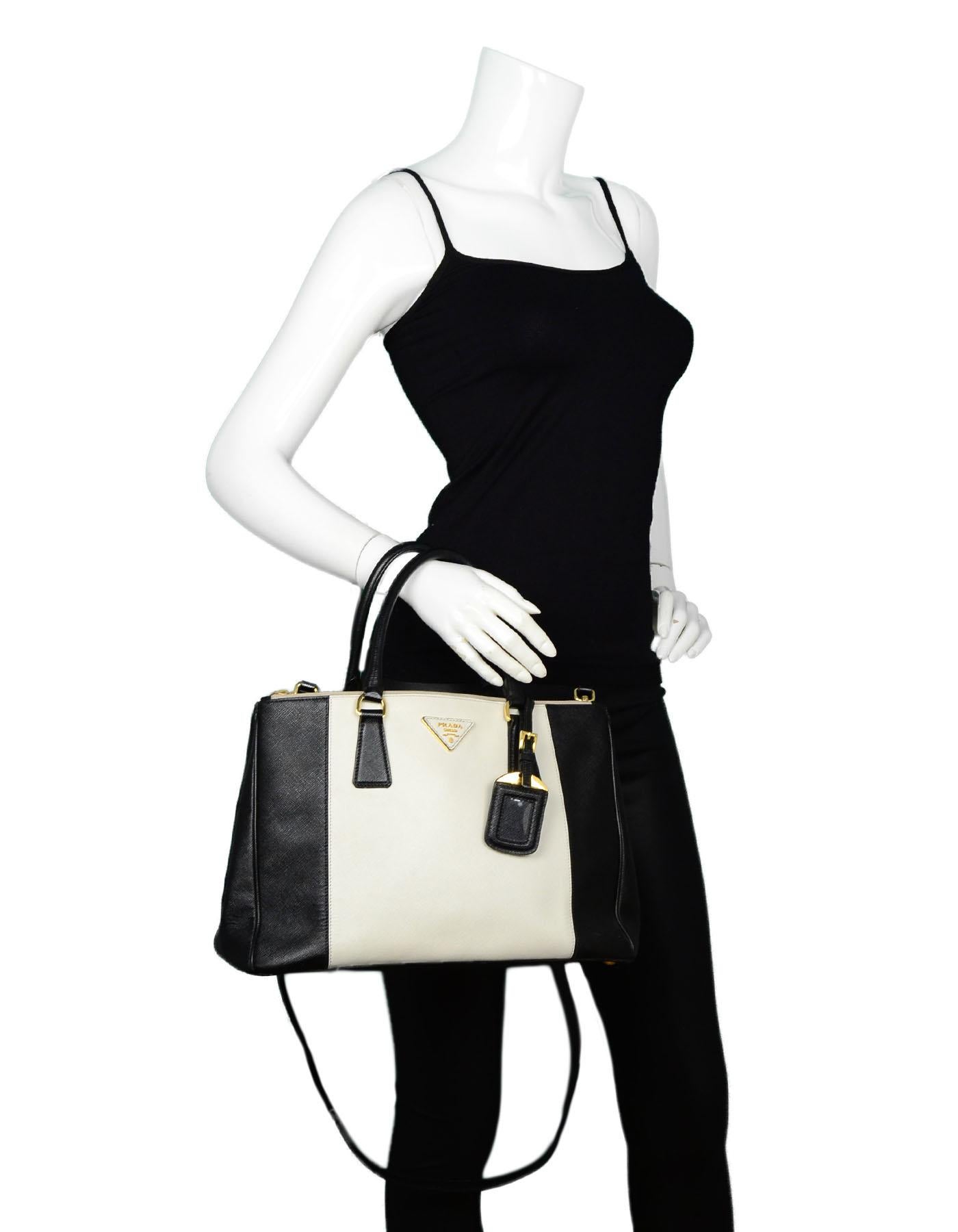 Prada Black & White Saffiano Leather Medium Double Zip Tote Bag B2274C, features removable crossbody strap.

Made In: Italy
Year of Production: 2013
Color: Black, White
Hardware: Goldtone hardware
Materials: Leather
Lining: Black monogram