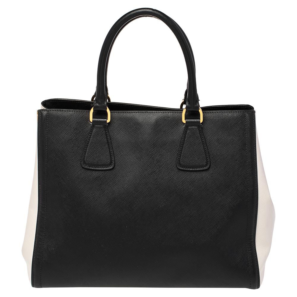This Saffiano Lux Parabole tote by Prada exudes style and class in equal measure. Meticulously crafted with Saffiano Lux leather and gold-toned metal fittings, this sturdy tote is complemented by a spacious nylon interior for your daily belongings.