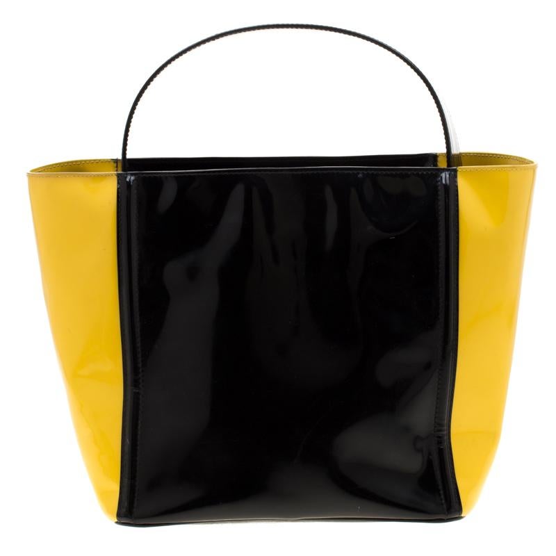 You will enjoy parading this bag from Prada. It comes made from patent leather and features a single top handle, the logo on the front and metal feet. It is equipped with a leather-lined interior meant to hold all your daily essentials with