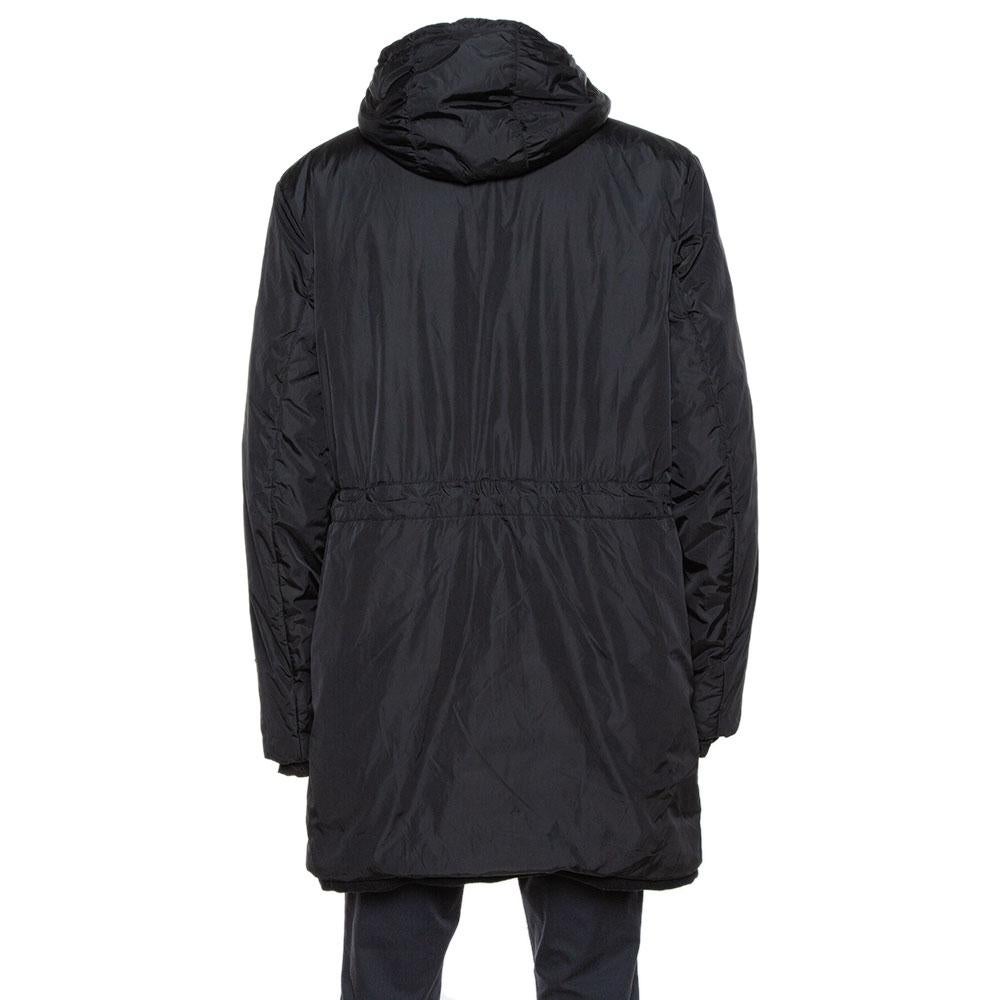 The classic black hue and the puffer style make this Prada coat a covetable piece. It exhibits a long silhouette and a hoodie at the back that adds a cool quotient to the coat. Equipped with long sleeves and a zip fastening, wear this one for an