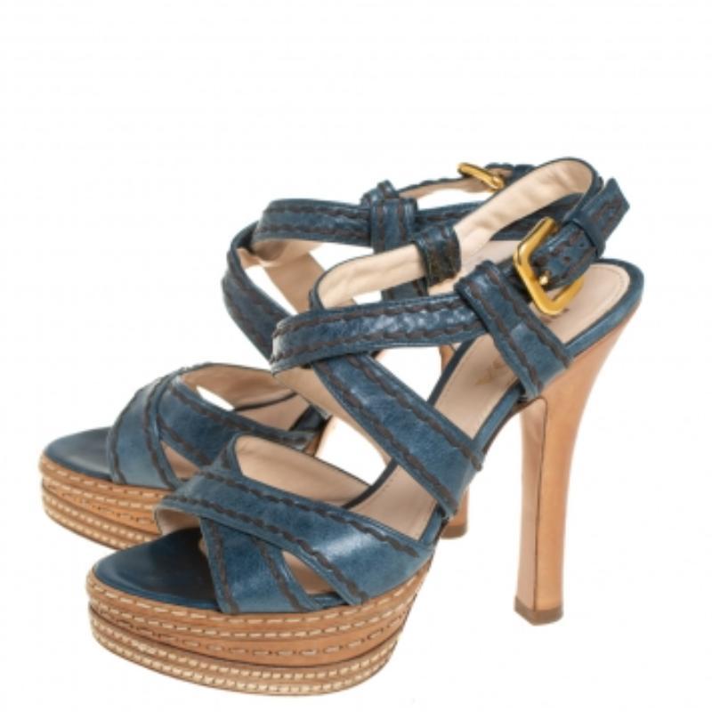 Grab these stylish and versatile Prada sandals now. They are crafted in Italy and made from blue & tan leather. They have cross straps with stitch detailing, platforms, buckled ankle straps and 12 cm heels. They are finished with leather insoles.