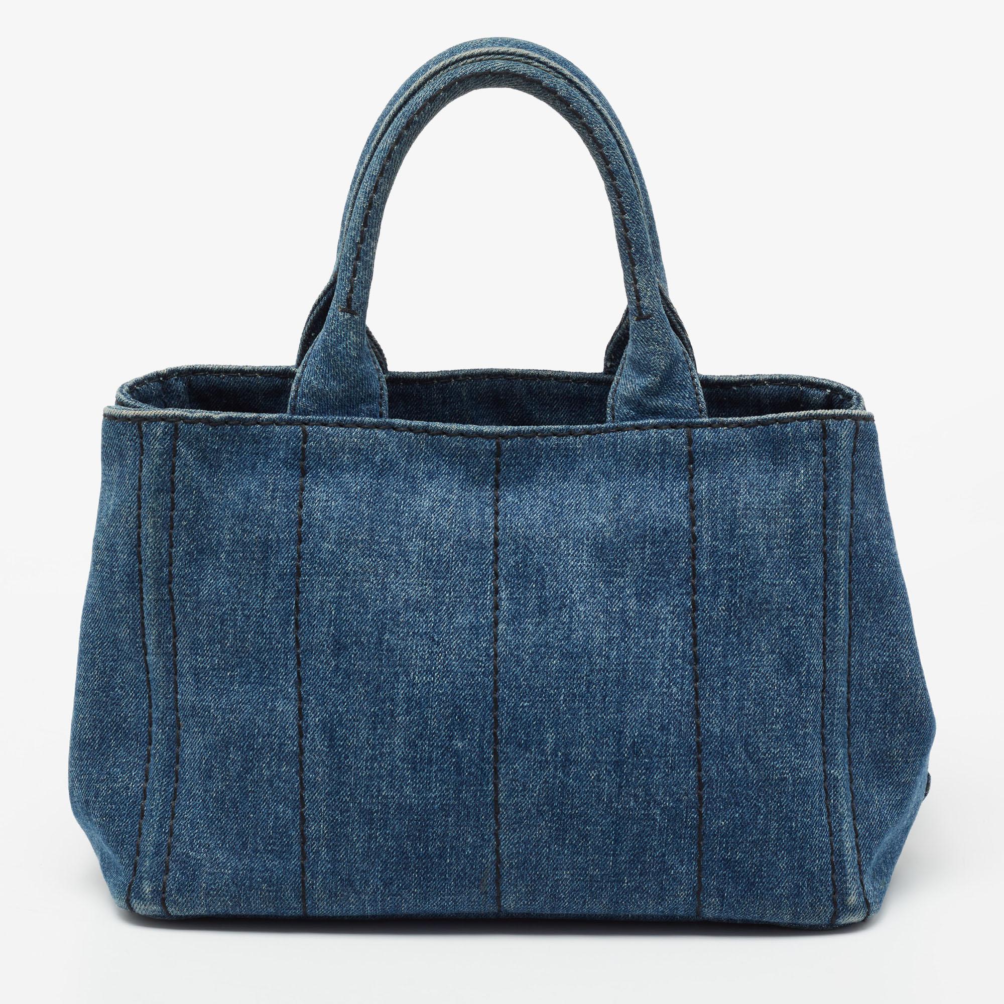 This designer tote from the House of Prada is super classy and functional, perfect for everyday use. It is made from blue denim on the exterior with the brand logo adorning the front. It has two handles.

