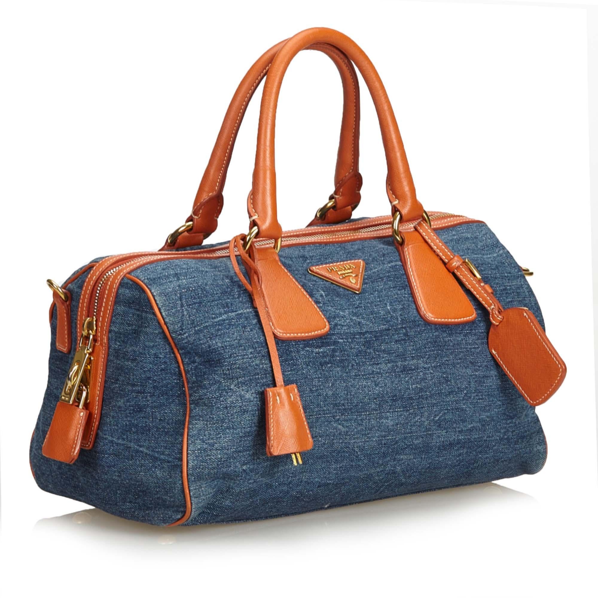 This satchel features a denim body with saffiano leather trim, rolled leather handles, top zip closure, and interior zip and slip pockets. It carries as B+ condition rating.

Inclusions: 
Authenticity Card

Dimensions:
Length: 18.00 cm
Width: 31.00