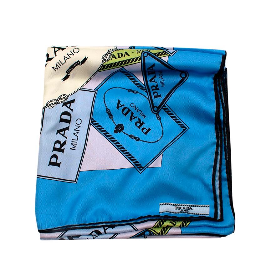 Prada Blue & Green Silk Twill Labels Motif Scarf 90cm
 

 - Silk twill square with labels motif in tonal blue hues
 - Hand rolled edges
 - Includes presentation gift box
 

 Materials 
 100% Silk 
 

 Made in Italy 
 

 PLEASE NOTE, THESE ITEMS ARE