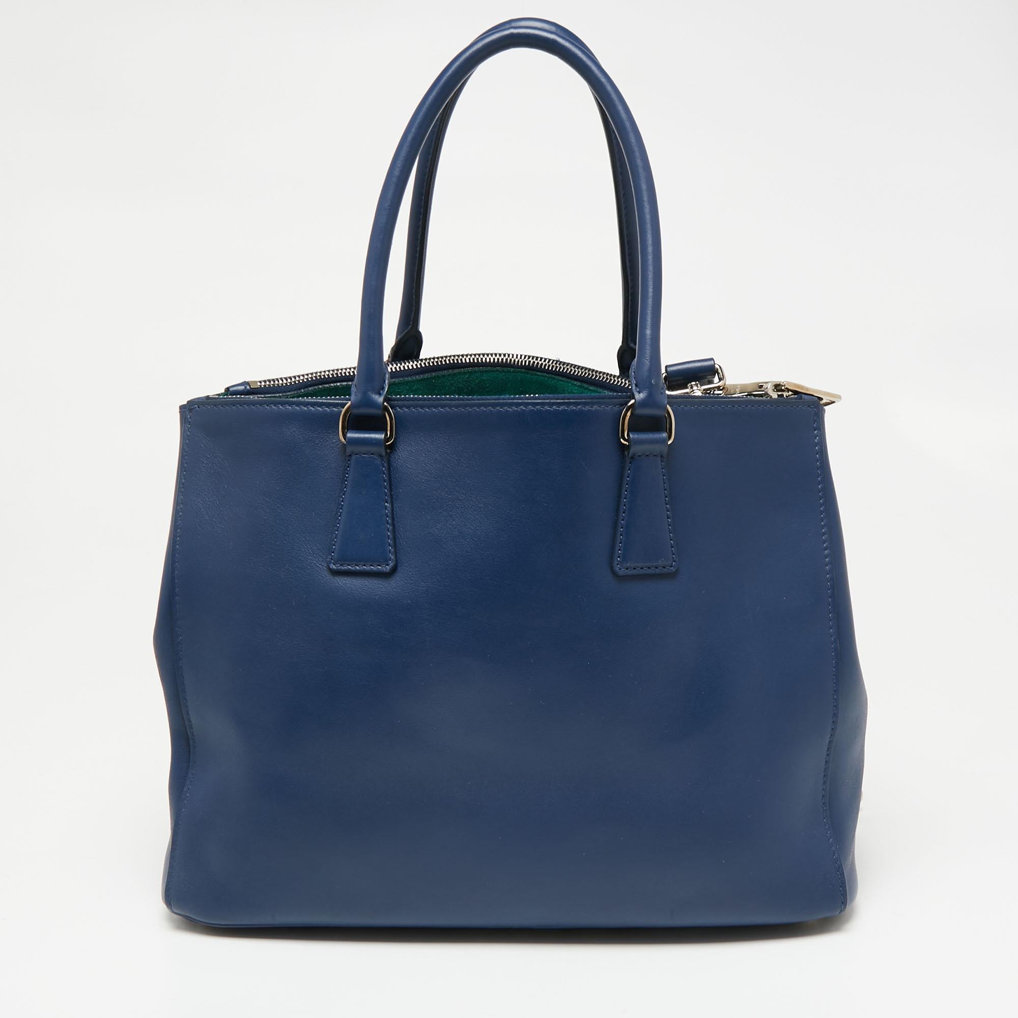 Loved for its classic appeal and functional design, Galleria is one of the most iconic bags from the house of Prada. This beauty in blue is crafted from leather and is equipped with two top handles, the brand logo at the front, and a shoulder strap.